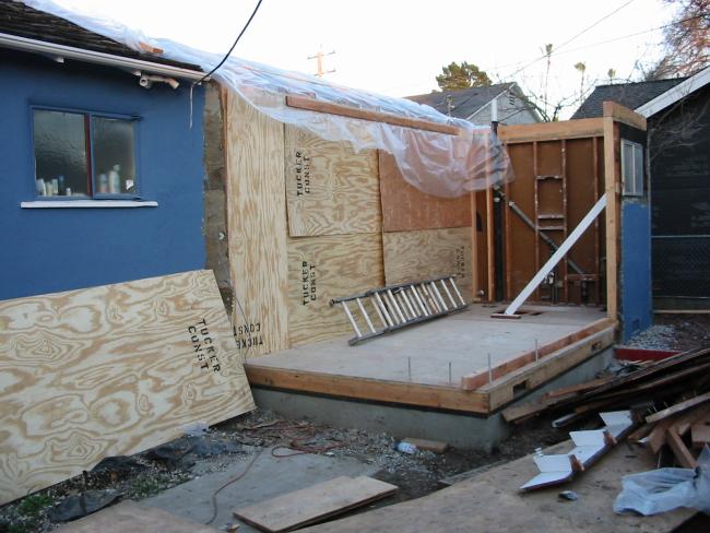 bedroom closed off with plywood, roof covered with plastic
